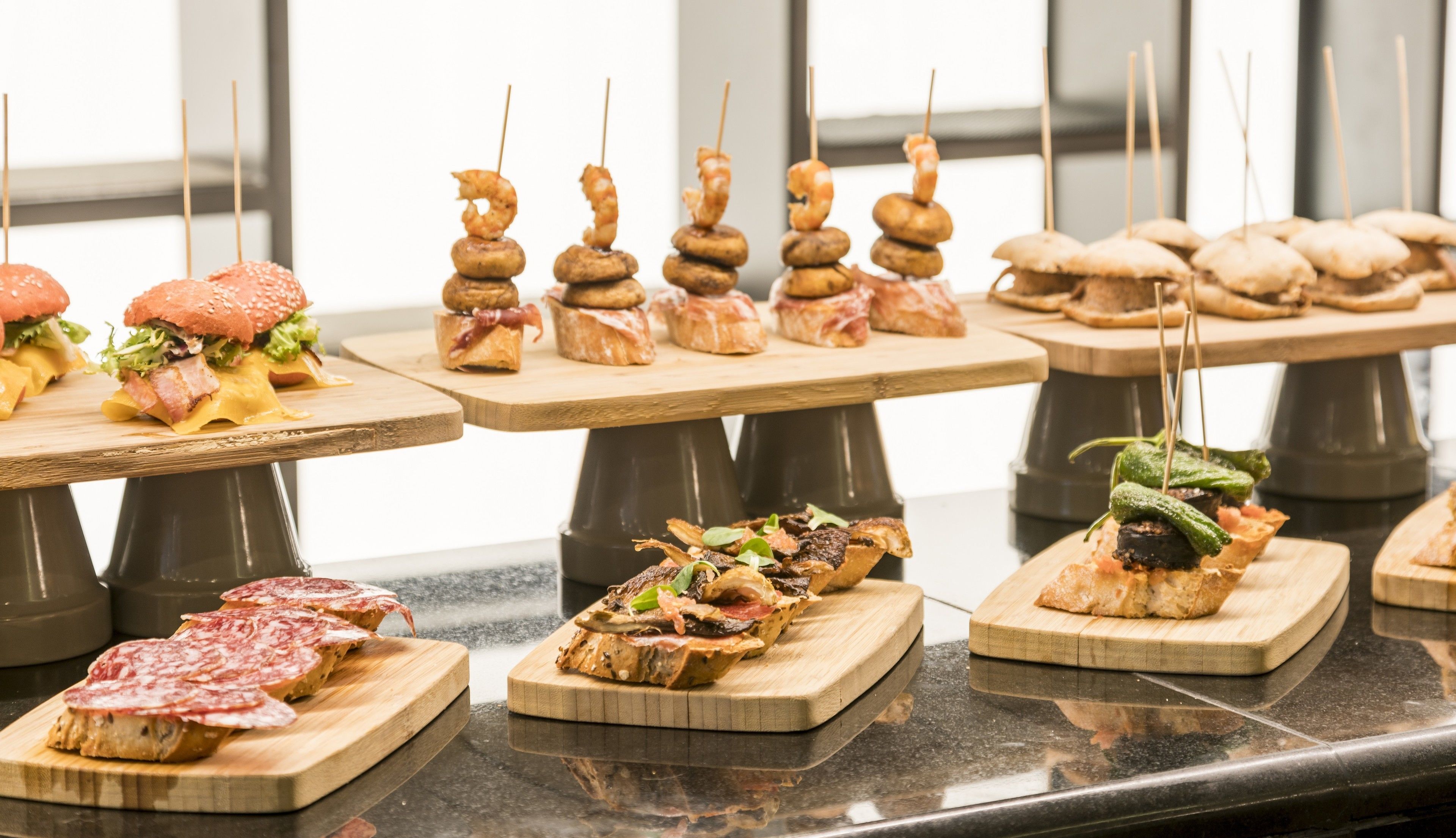 A buffet with various food items including skewers, sandwiches, and appetizers.