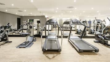 A modern gym with treadmills, elliptical machines, and weightlifting equipment.