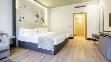Una habitación de hotel moderna con una cama grande, un escritorio y una silla.