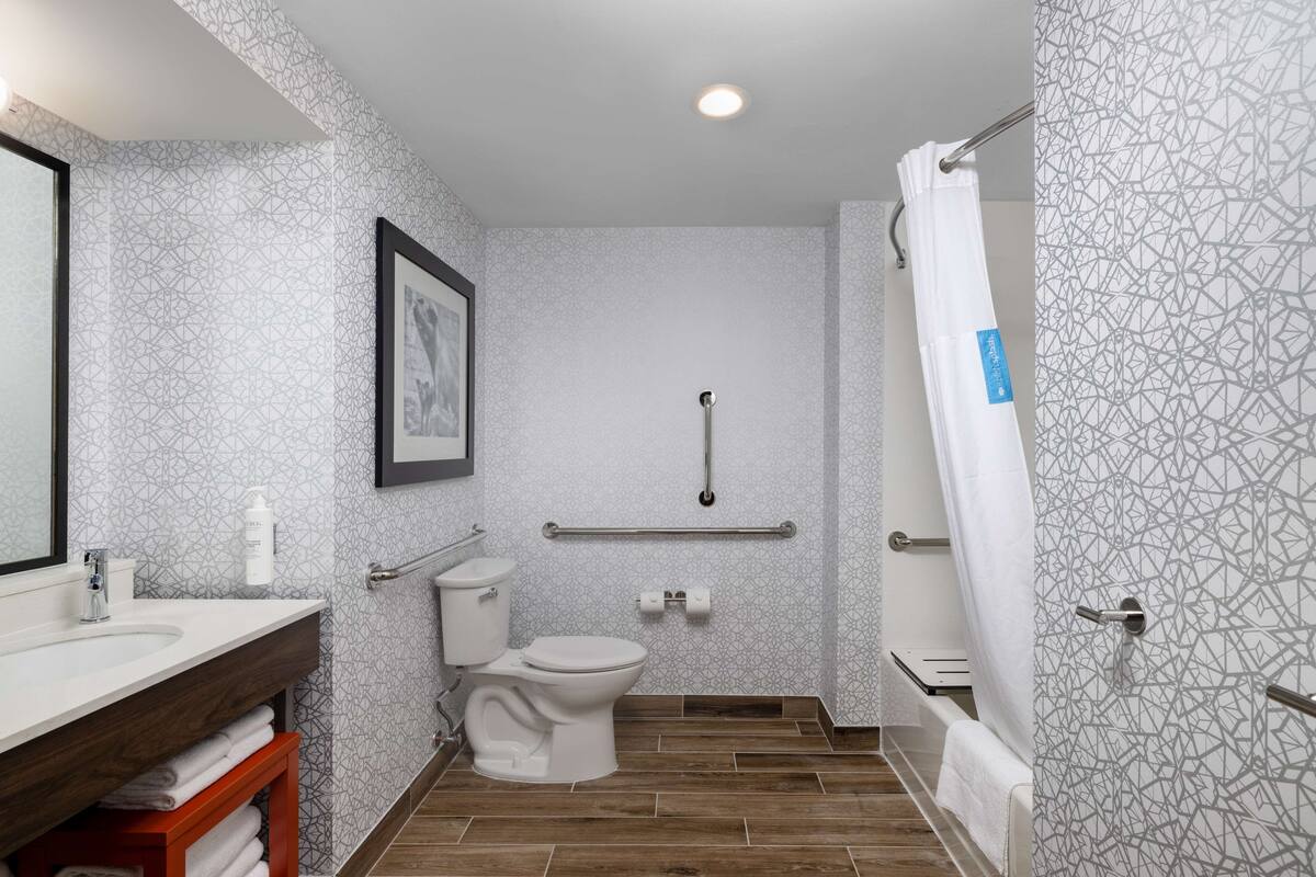 A bathroom with a toilet, sink, and shower.