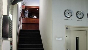 Een trap die leidt naar een kamer met klokken die verschillende tijdzones aangeven.