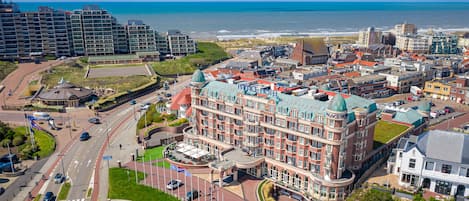 Un grand hôtel historique doté d’une cour intérieure et offrant une vue sur la mer.