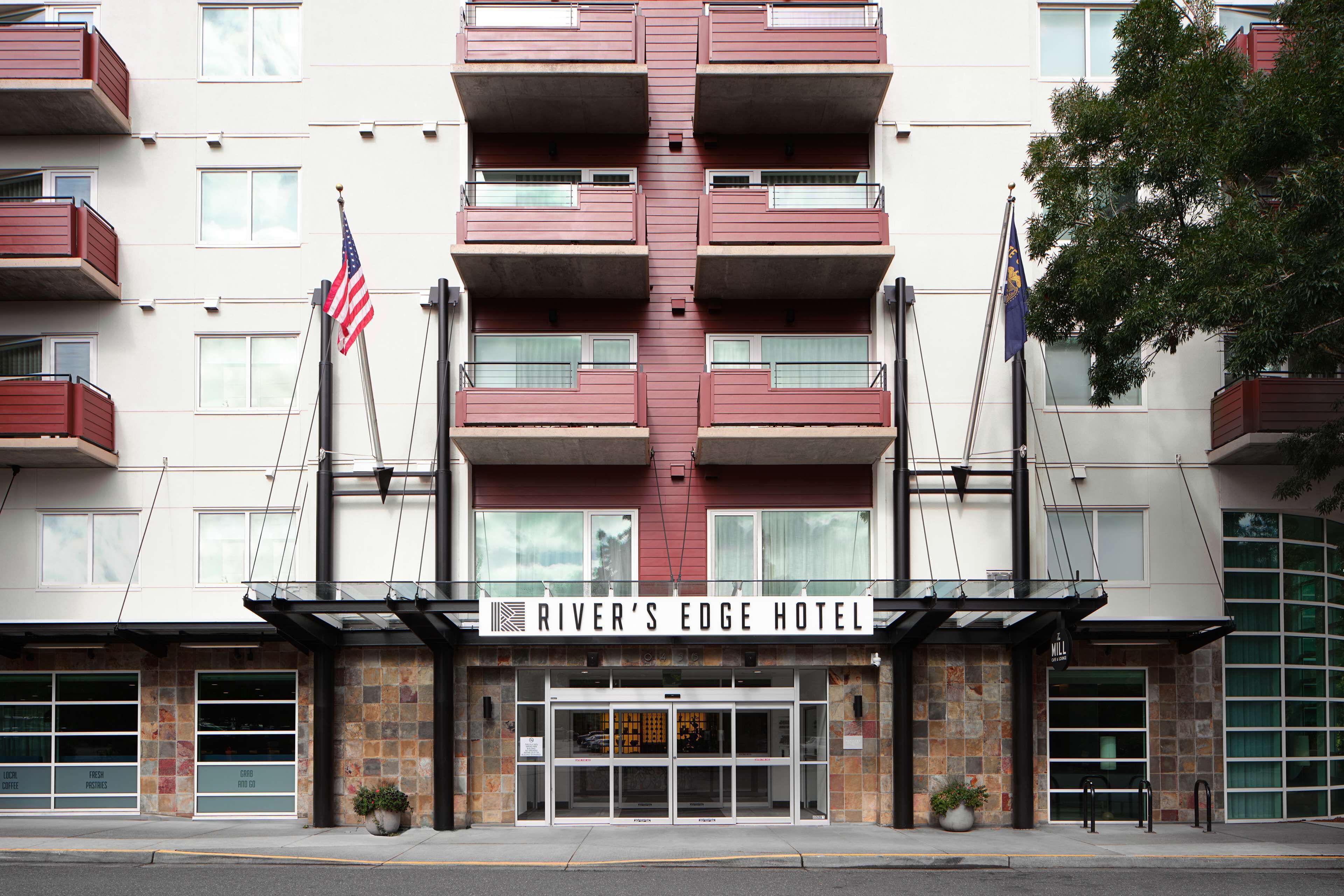 Ein mehrstöckiges Hotel mit einem zentralen Eingang, Balkonen und einer US-amerikanischen Flagge.