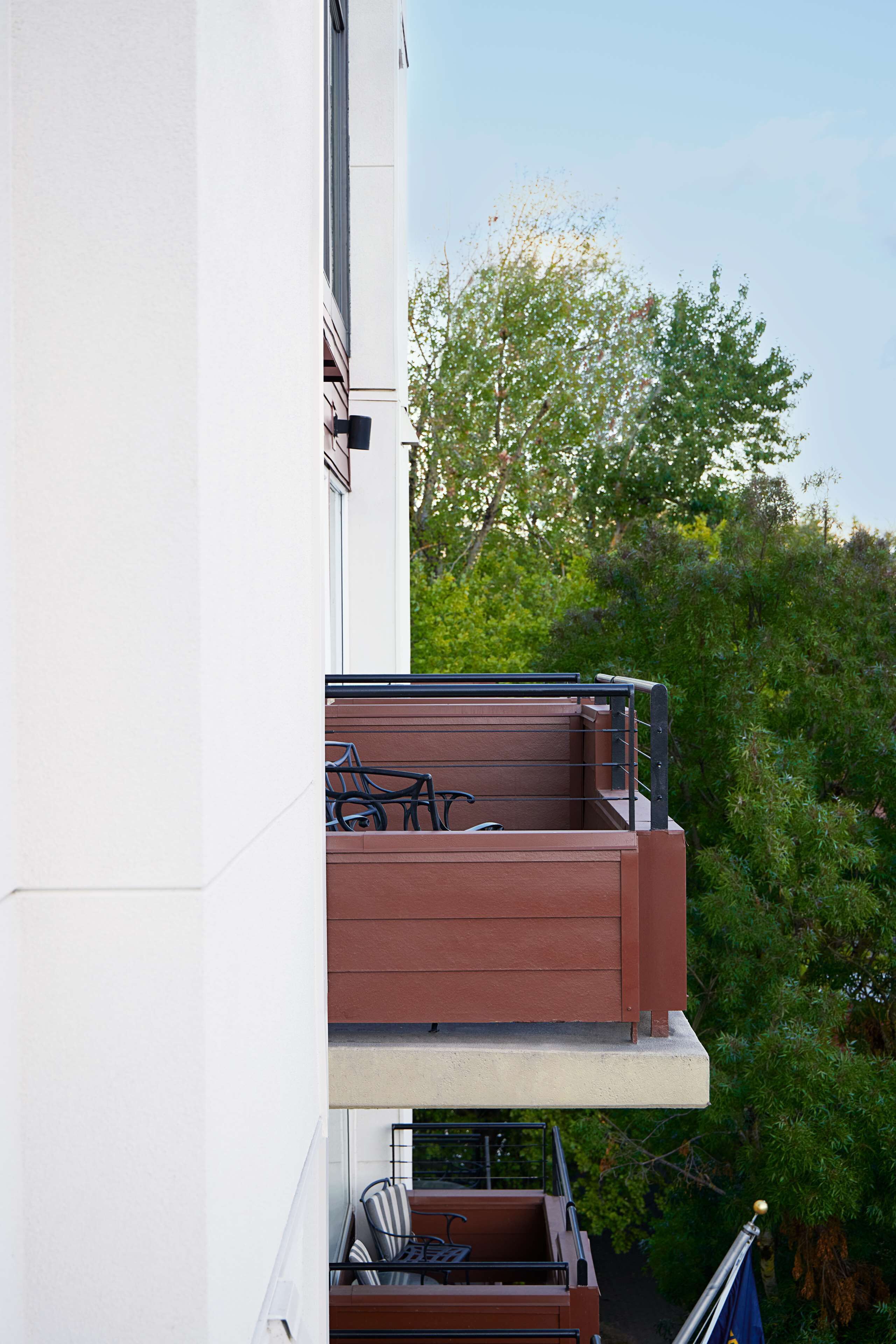 A balcony with a bicycle, a table, and chairs.