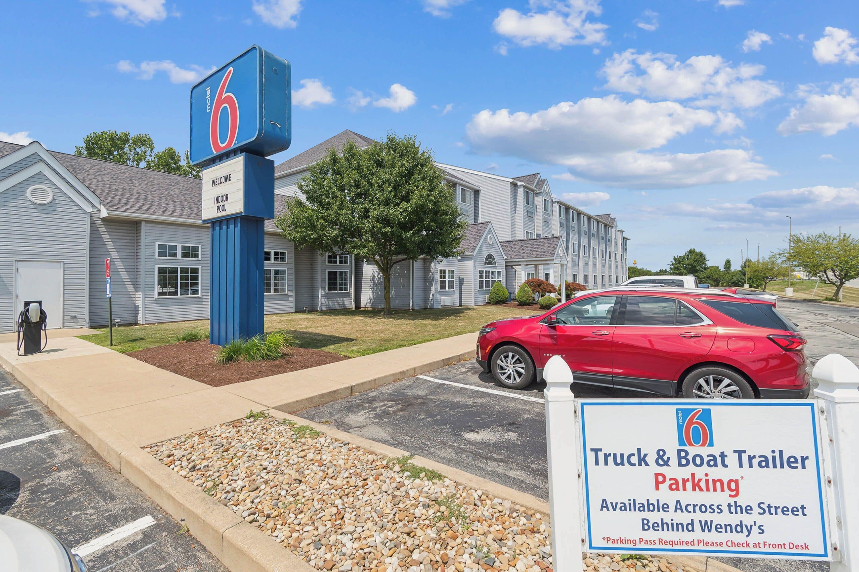 A motel with a sign indicating a truck and boat trailer parking area available across the street behind Wendy's.