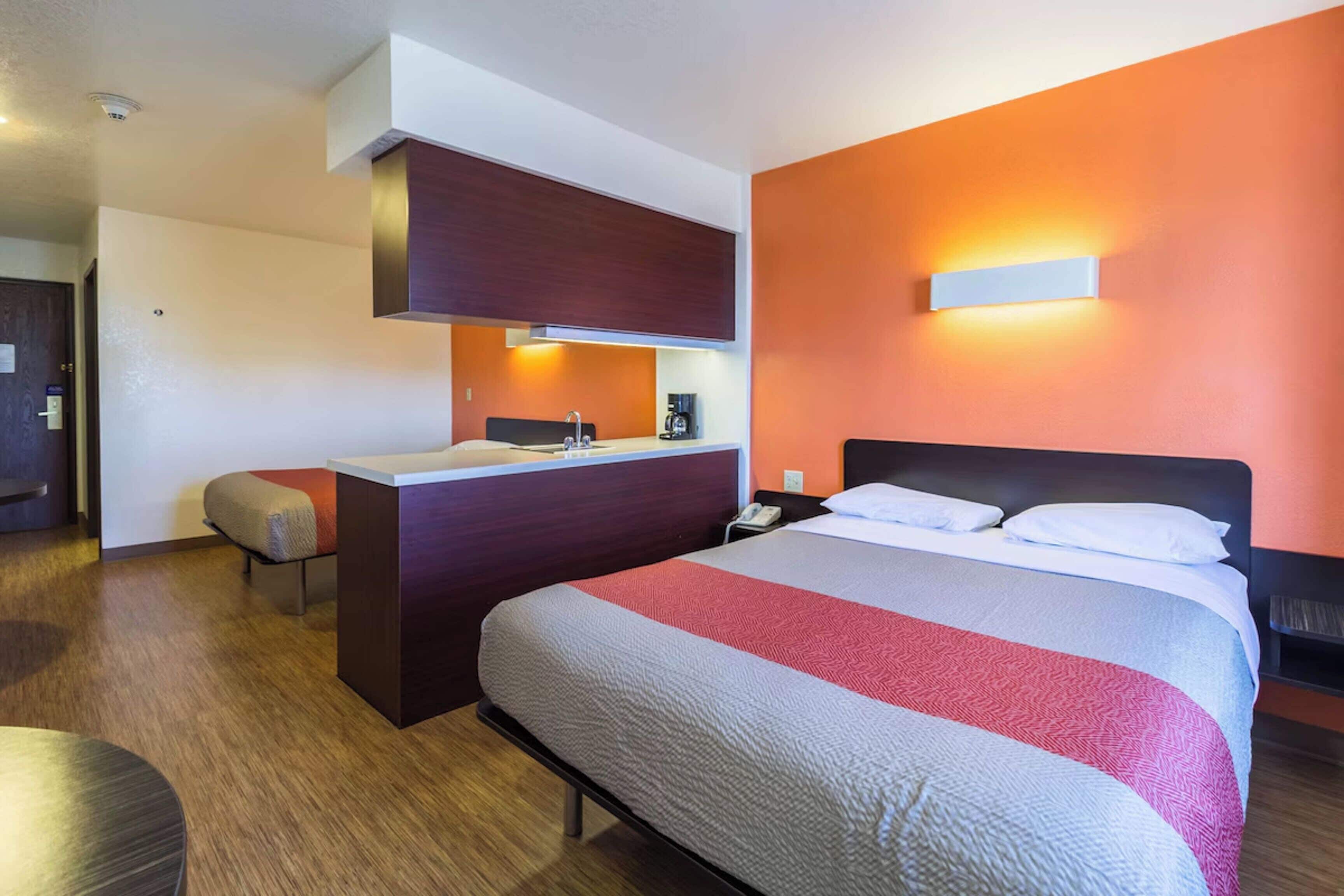 Ein Hotelzimmer mit Bett, Schreibtisch und Badezimmer.