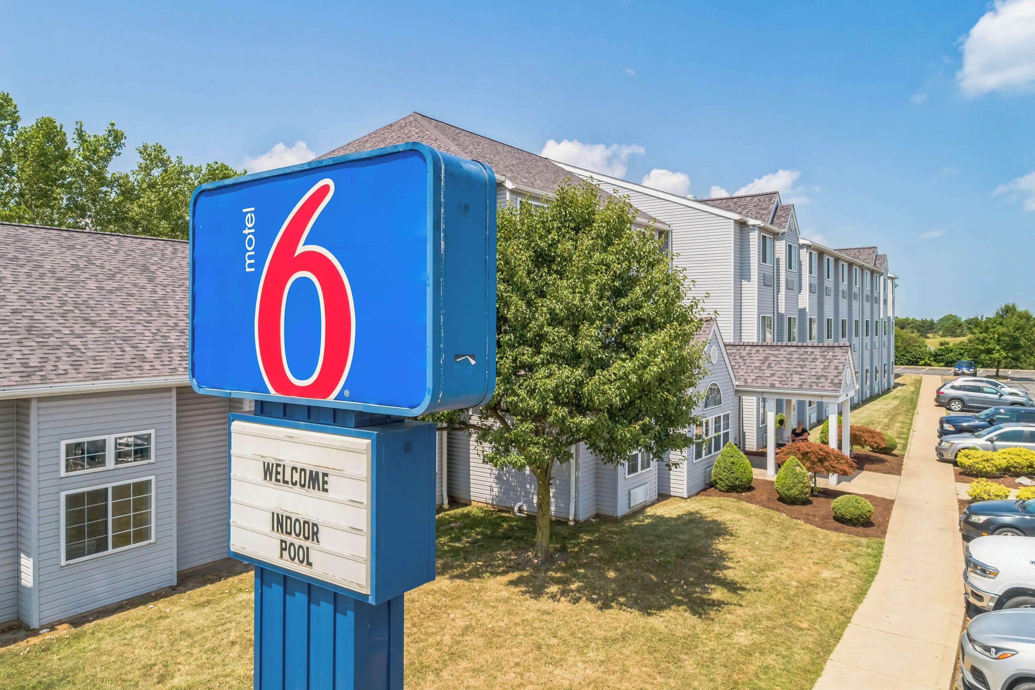 A motel sign with a number 6, a welcome sign, and an indoor pool sign.