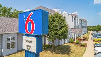 A motel sign with a number 6, a welcome sign, and an indoor pool sign.