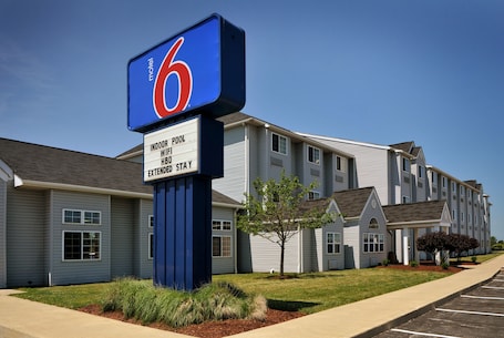 A motel with a sign indicating indoor pool, WiFi, and extended stay.