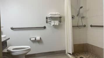 Kylpyhuone, jossa on wc, lasiovilla varustettu suihku, pyyhekoukku ja wc-paperiteline.