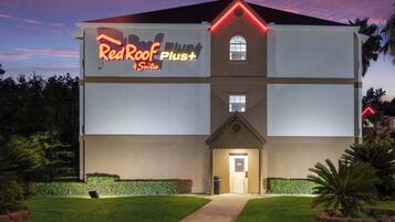 Un edificio con un letrero que dice 'RedRoof Plust Suites'.