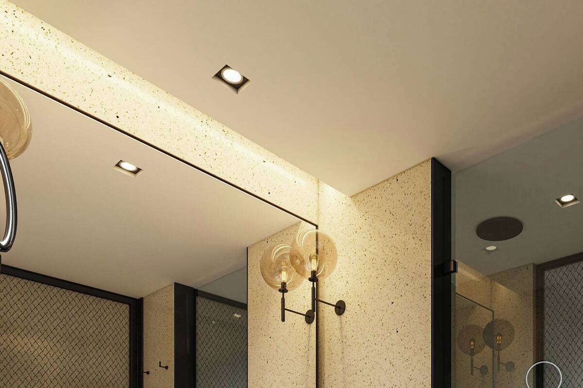 Une salle de bain moderne avec un grand miroir, un lavabo et un espace douche.