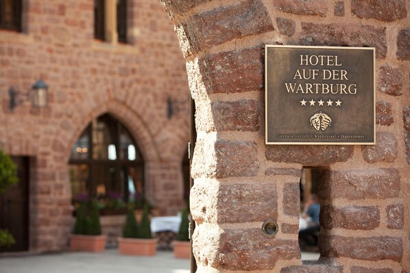 Letrero del Hotel Auf der Wartburg, con un muro de piedra de fondo.