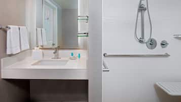 Een moderne badkamer met een wastafel, spiegel en douche.