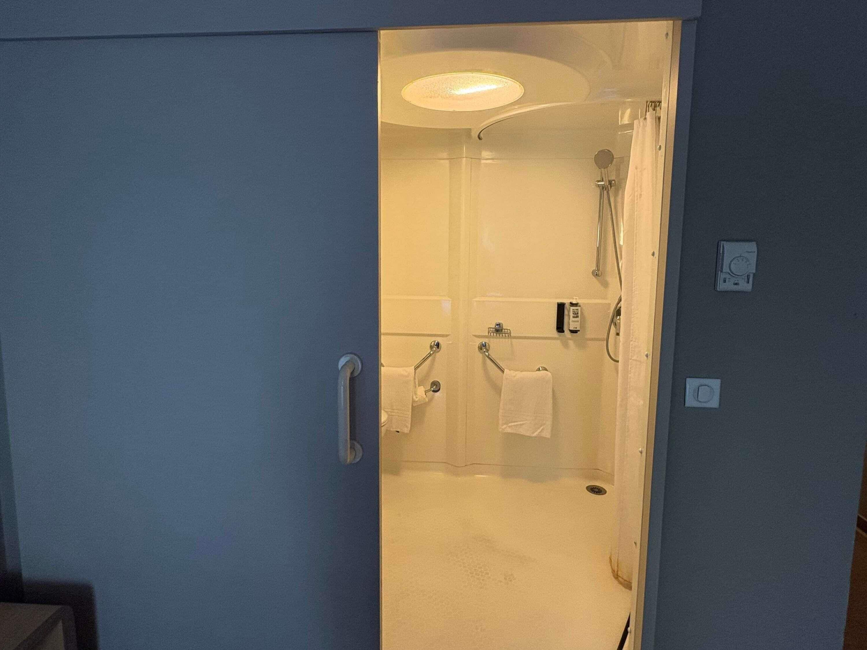 A bathroom with a shower, a toilet, and a sink.