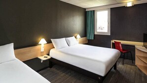 Una habitación de hotel con una cama grande, mesitas de noche con lámparas, un escritorio y una silla.