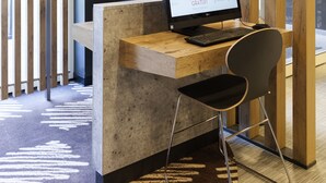 Un espai de treball modern amb un escriptori de fusta, un ordinador i una cadira.