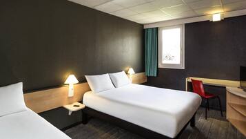 A hotel room with two beds, a desk, a chair, and a TV.