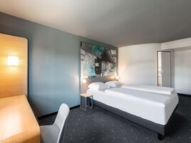Una habitación de hotel moderna con una cama individual, un escritorio y una silla.