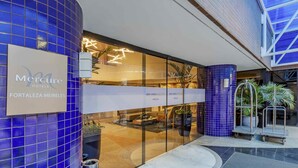 Eksteriørbillede af Mercure Forteza Meireles hotel med et moderne design, inklusive blå fliserede vægge og en glasindgang.