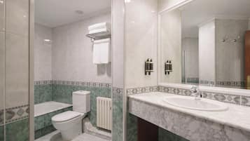 A bathroom with a toilet, sink, and shower.