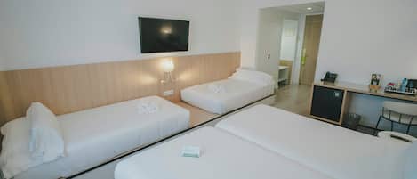 A hotel room with two single beds, a desk, a chair, a TV, and a mirror.