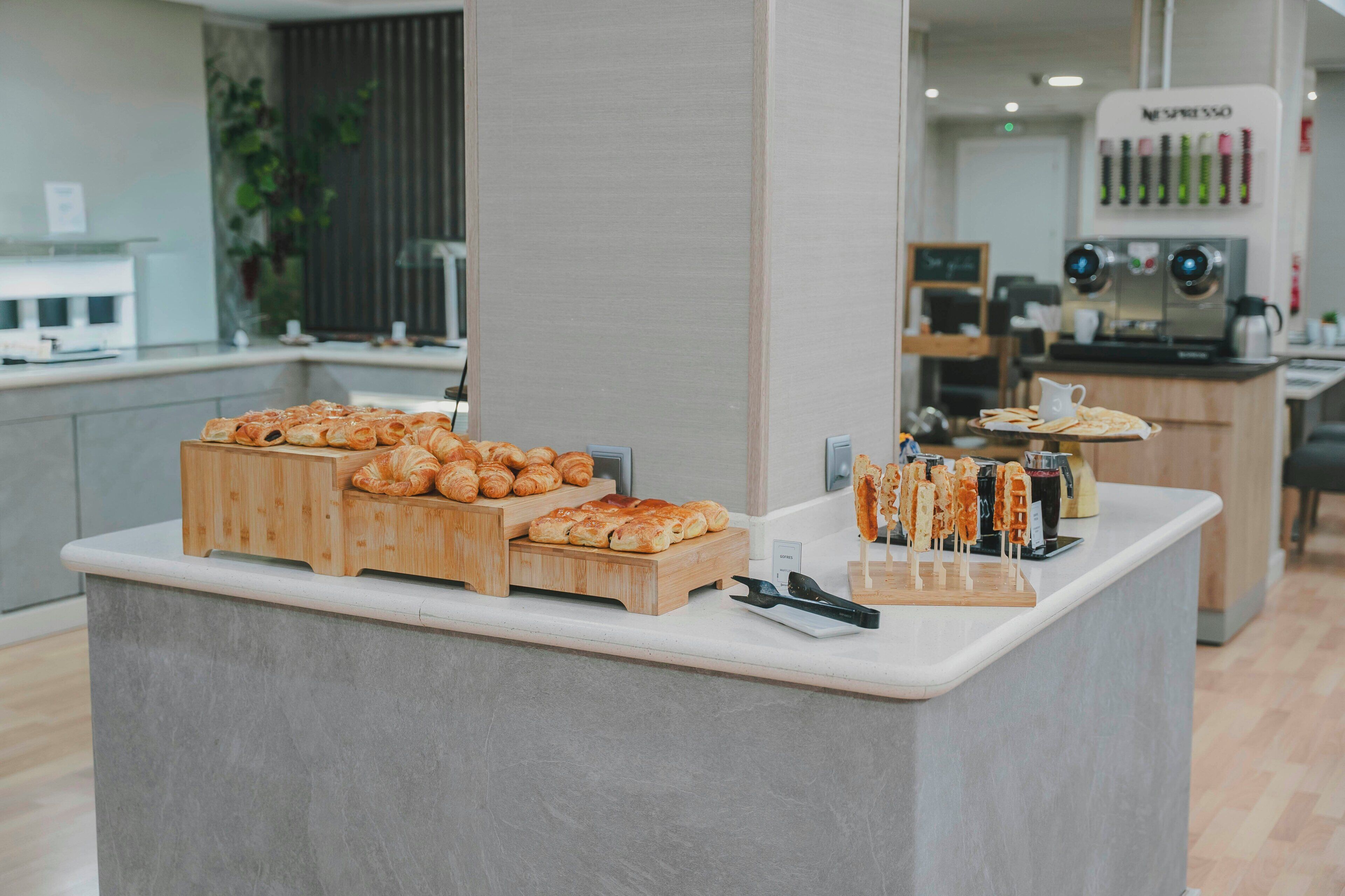 A bakery counter with various baked goods and a coffee machine in the background.