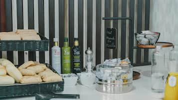 A breakfast buffet with bread, pastries, and condiments.