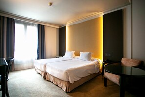 A hotel room with a large bed, a desk, a chair, and a small table. - Hotel Sercotel Ciudad de Oviedo (Oviedo)
