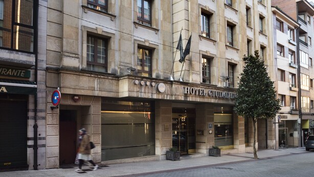 Un hotel de varios pisos con estilo arquitectónico clásico, que cuenta con grandes ventanales y una entrada destacada.