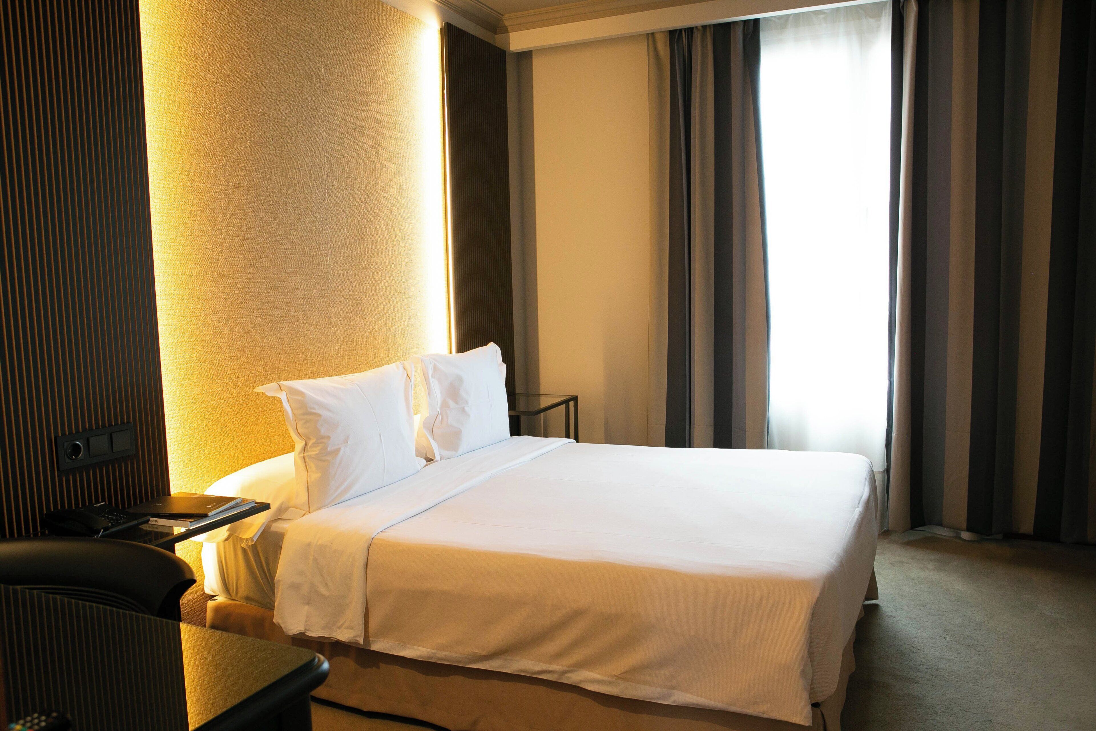 Una habitación de hotel con cama, escritorio y silla.