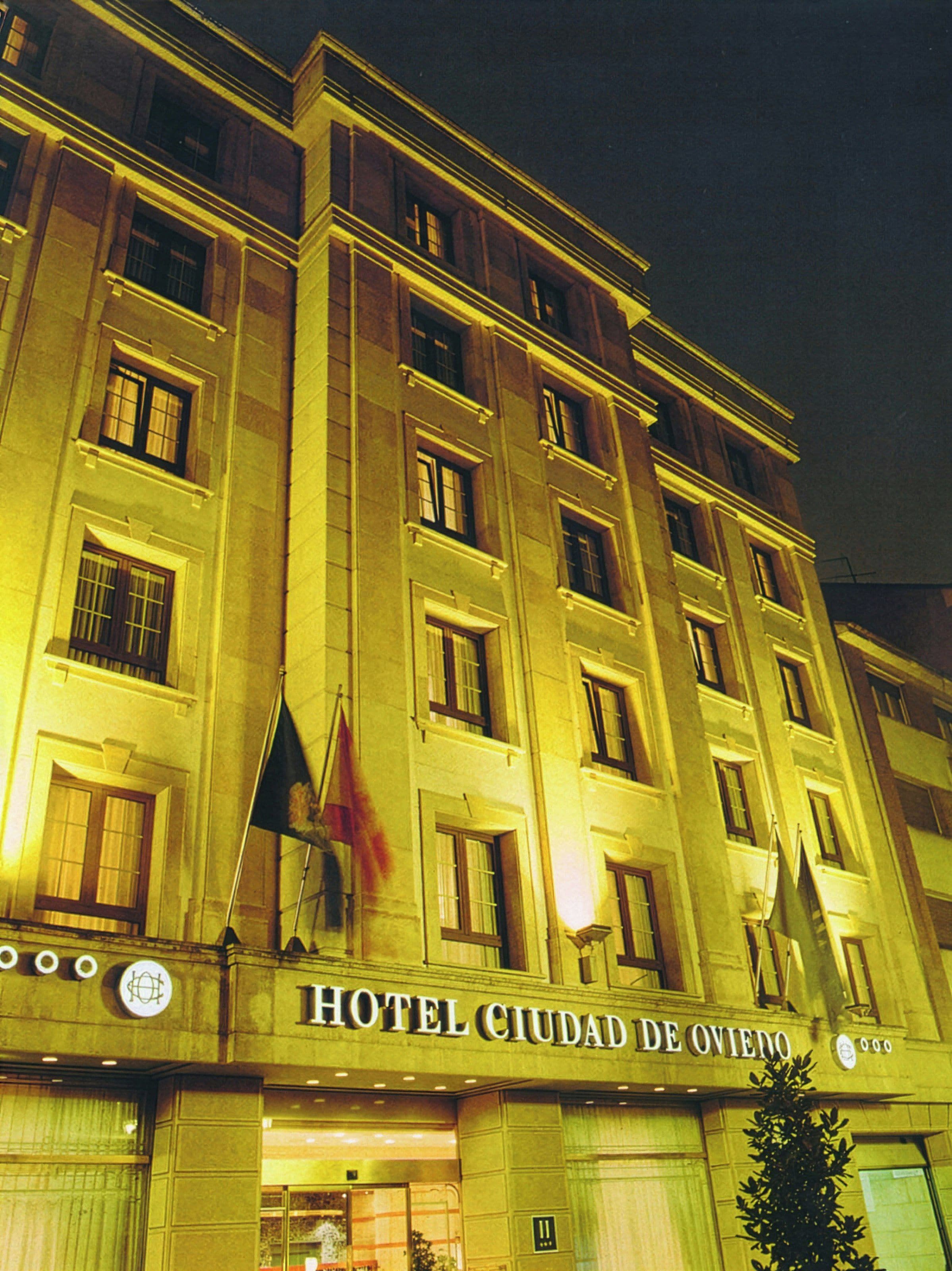 Un immeuble à plusieurs étages portant l’enseigne « HÔTEL CIUDAD DE OVIEDO », ce qui indique qu’il s’agit d’un hôtel.