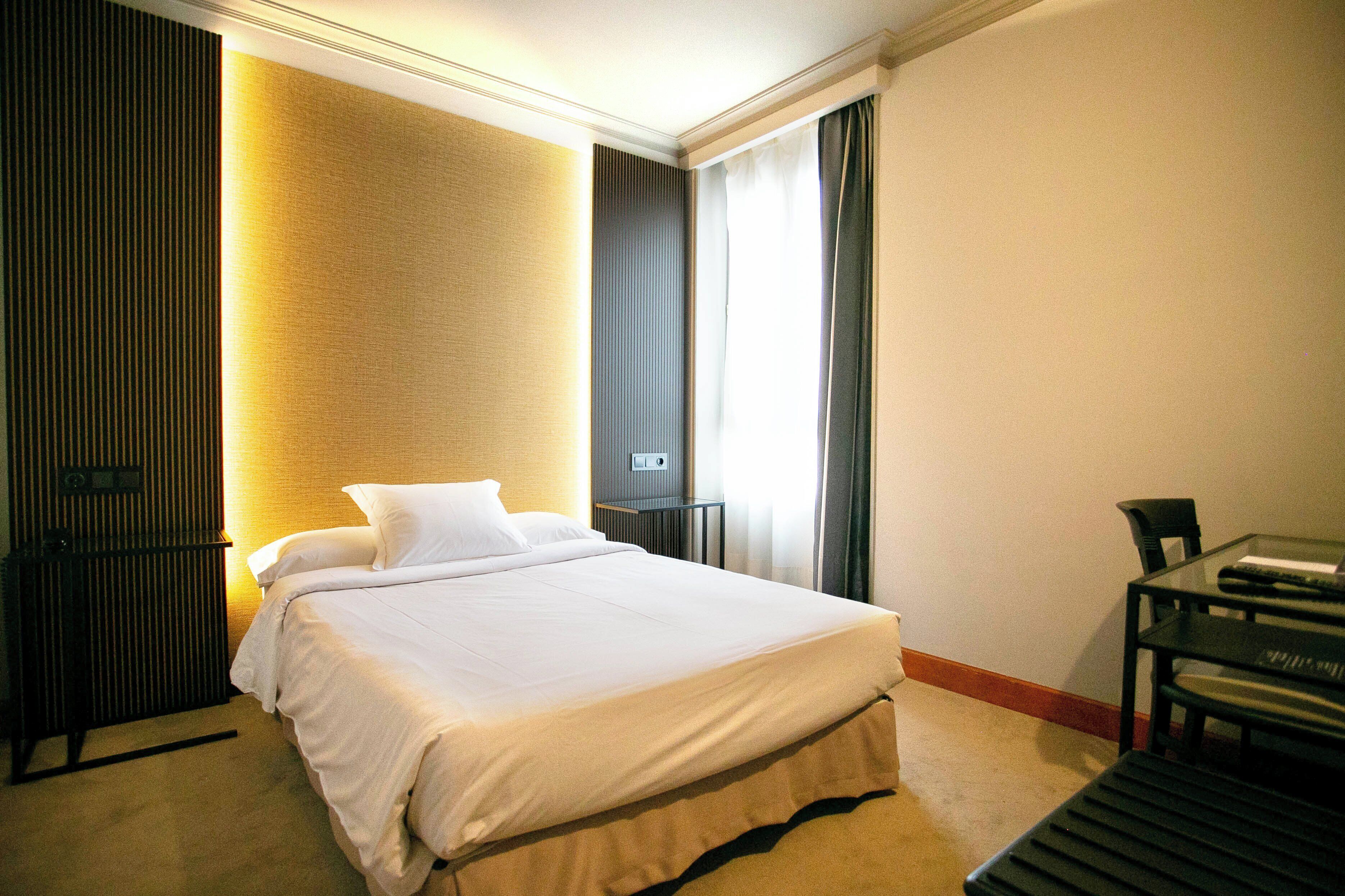 Ein Hotelzimmer mit Bett, Schreibtisch und Stuhl.