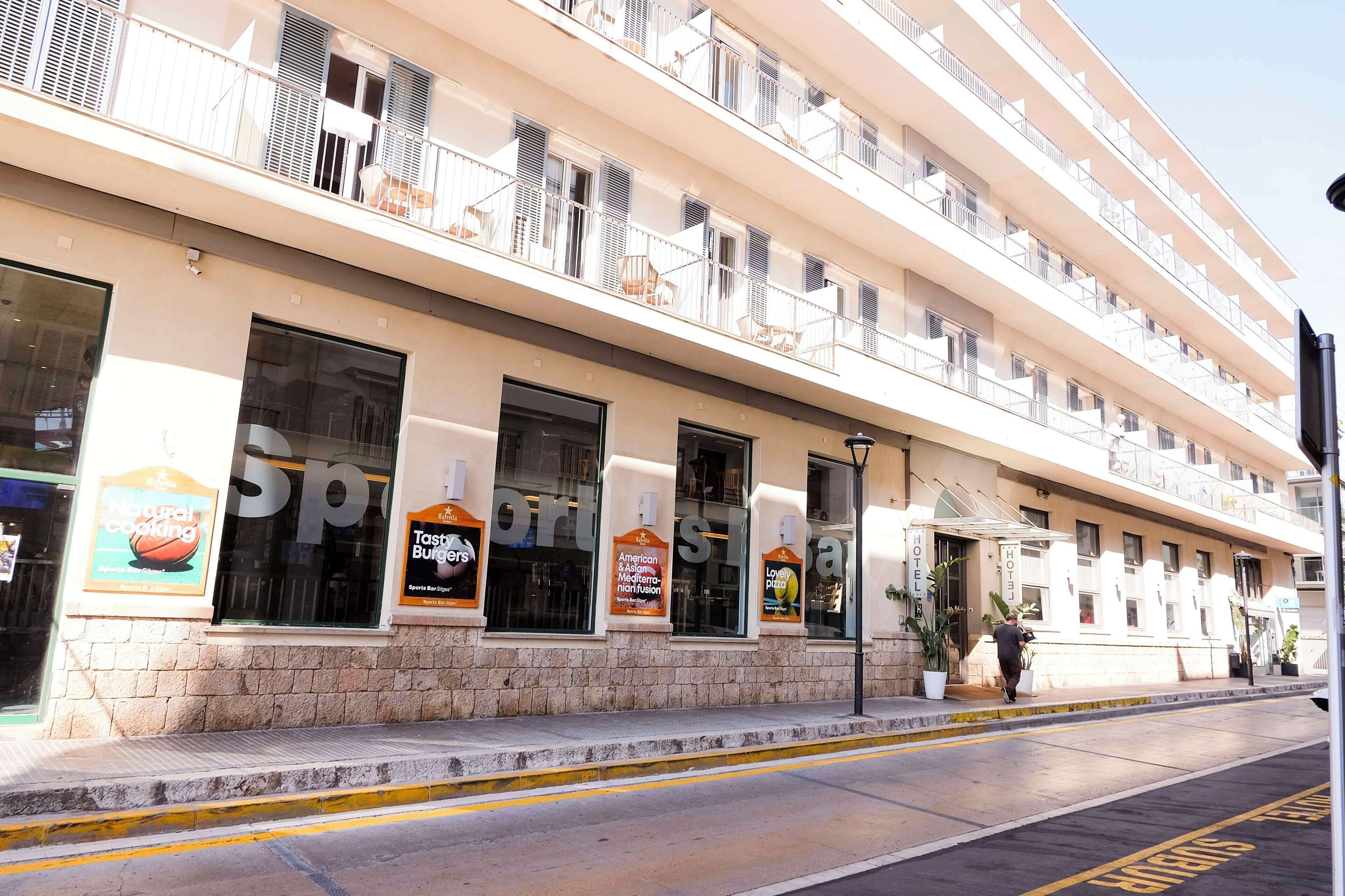 Un hotel de varios pisos con balcones, ventanas amplias y zonas de estar al aire libre.