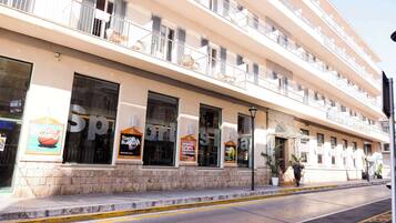 Un hotel de varios pisos con balcones, ventanas amplias y zonas de estar al aire libre.