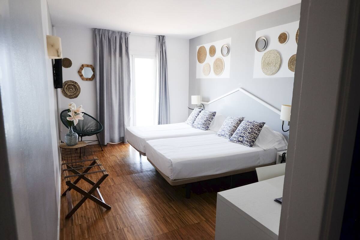 A modern bedroom with a bed, bedside table, lamp, and decorative wall art.