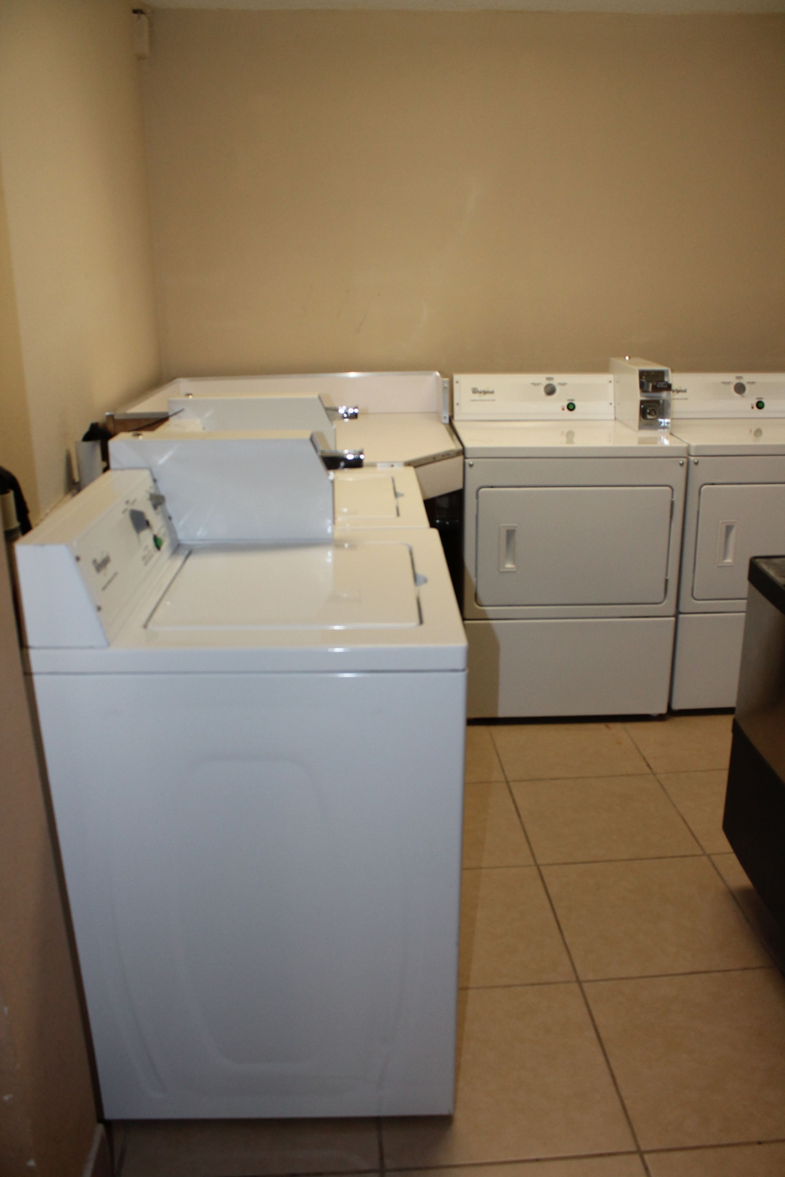 A laundry area with multiple washing machines and dryers.