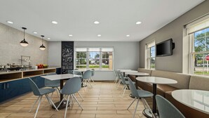 A modern cafe with a brick wall, a chalkboard with motivational writing, and a large window offering a view of the outdoors. - TownePlace Suites by Marriott -Minneapolis West/StLouis Park (St. Louis Park)