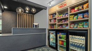 A snack bar with shelves of chips and snacks, a Pepsi refrigerator, and a water cooler. - TownePlace Suites by Marriott -Minneapolis West/StLouis Park (St. Louis Park)