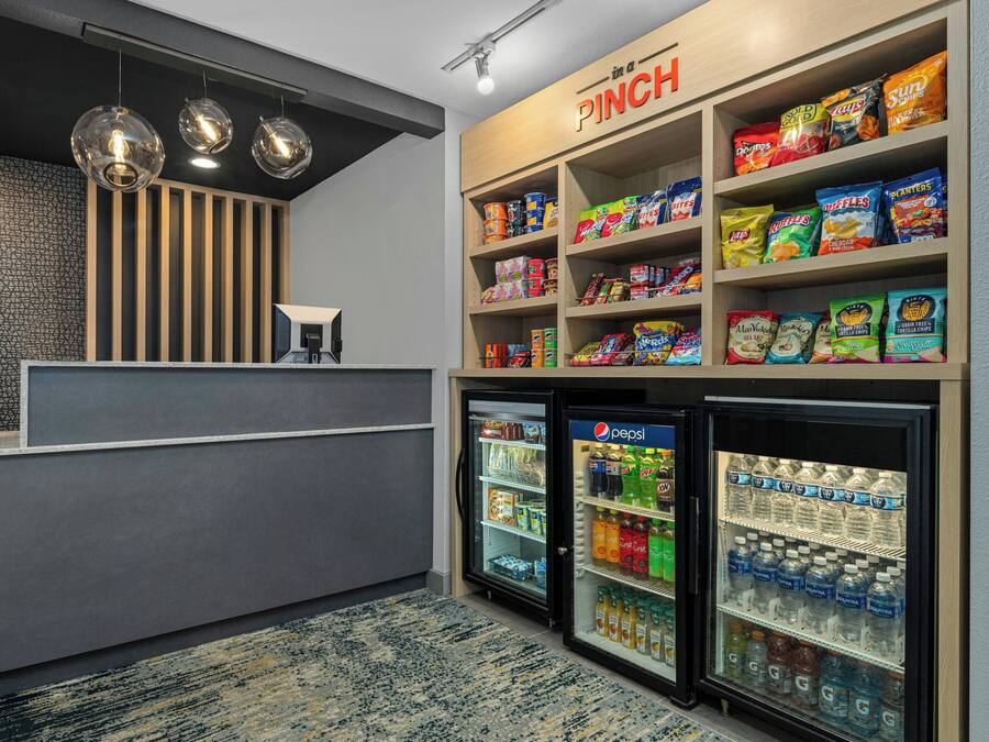 A snack bar with shelves of chips and snacks, a Pepsi refrigerator, and a water cooler.