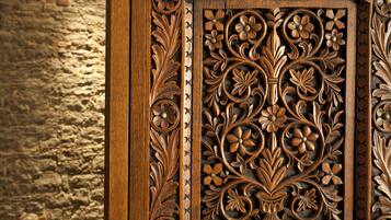 Un intaglio in legno dettagliato con motivi floreali e a foglia, probabilmente parte di un mobile o di un elemento decorativo architettonico.