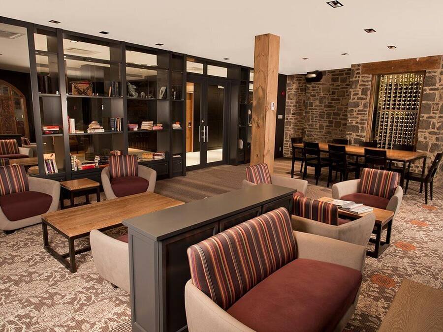 A modern lounge area with sofas, a coffee table, and a bookshelf.