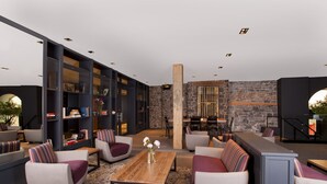 Un espace de détente moderne avec des canapés, une table basse et des étagères.