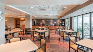 A hotel lobby with a bar area, tables, and chairs. - Wingate by Wyndham Lexington (Lexington)