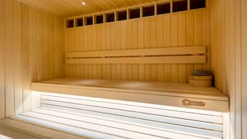 Una sauna de madera con bancos y un asiento con el logo de la marca, además de un pequeño recipiente.