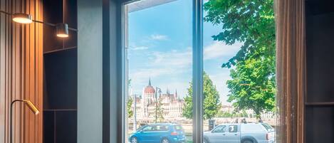 Un comedor con una mesa dispuesta para cuatro personas, ventanas amplias y vistas a la ciudad.