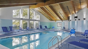A swimming pool with blue lounge chairs and a wooden ceiling. - Hotel Wave Rehoboth Beach (Rehoboth Beach)