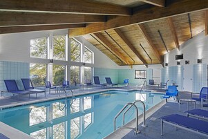 Una piscina techada, sillones reclinables de piscina