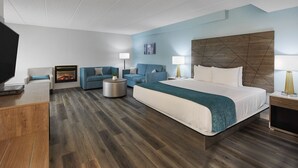 A modern hotel room with a large bed, two sofas, a TV, and a fireplace. - Hotel Wave Rehoboth Beach (Rehoboth Beach)