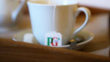 Una taza con el logotipo de PG, una cuchara y un fondo desenfocado.